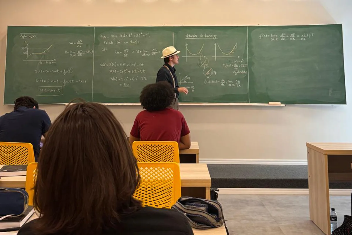 A gente virado para a turma, explicando o que acabou de escrever no quadro